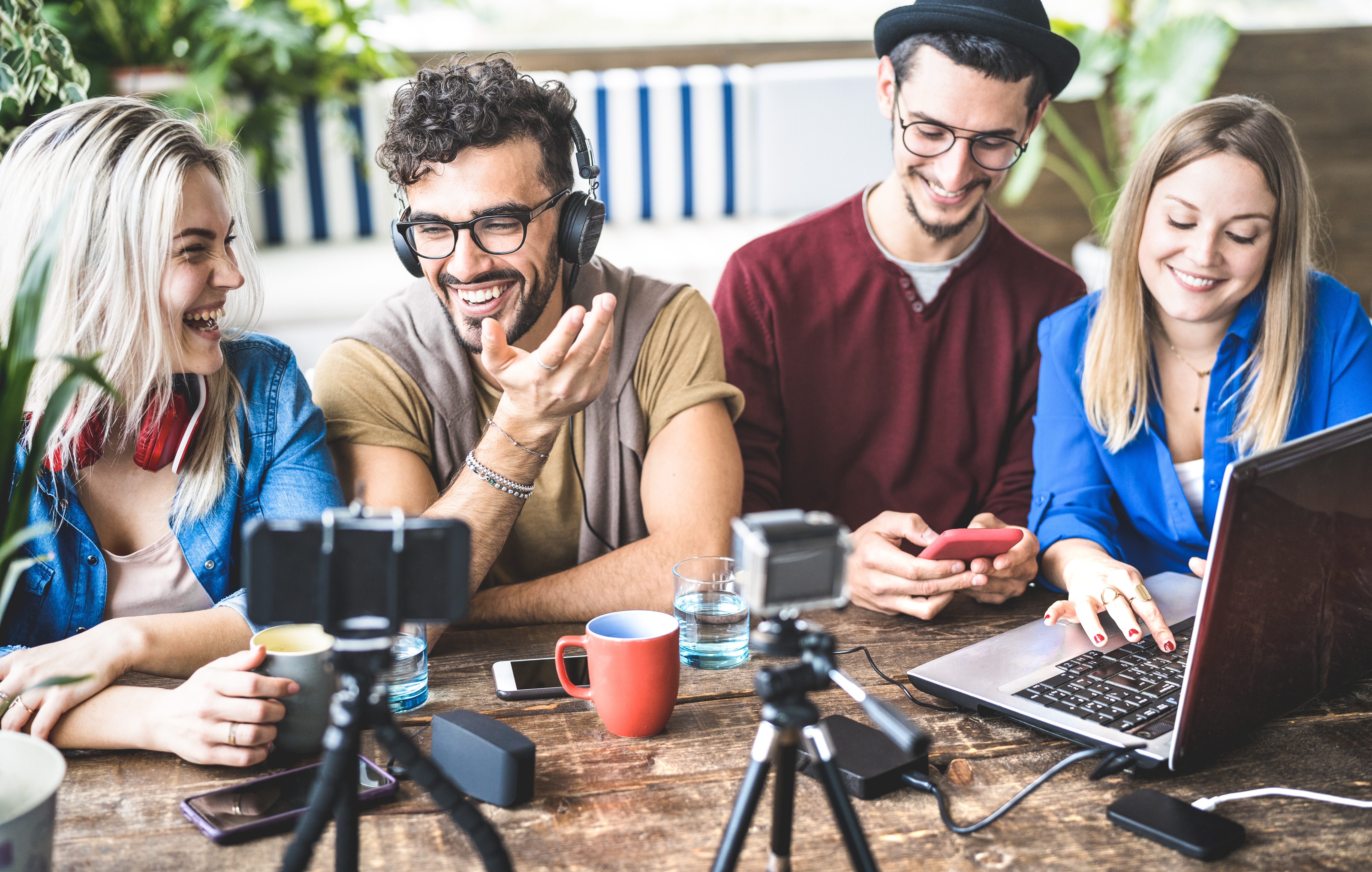 Young happy friends sharing content on streaming platform with digital web camera