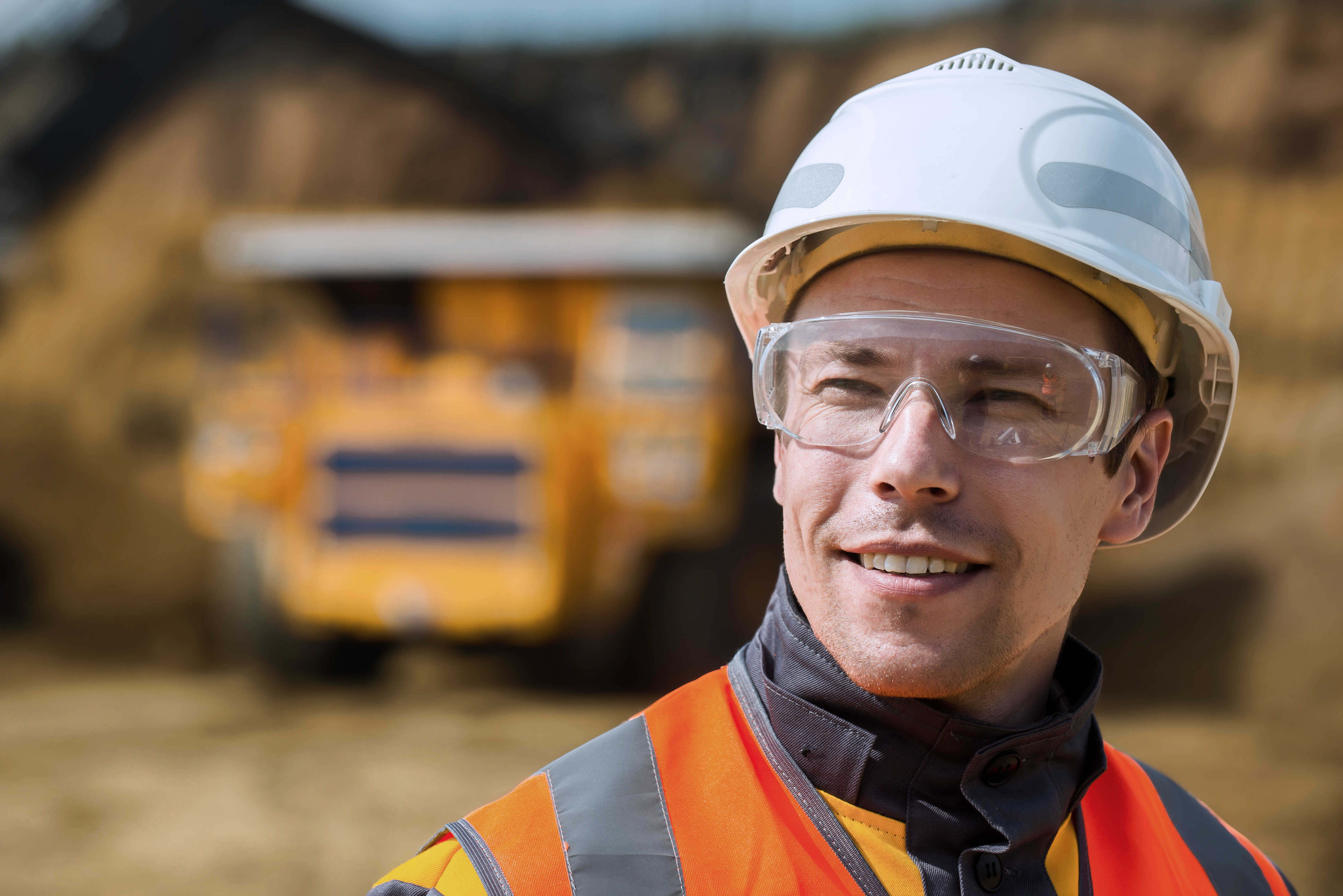 Miner work in PPE with a blurred background of a truck